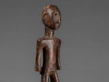a small wooden figure of a man with a hat on his head