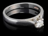 une image d'une bague en diamant sur une surface noire