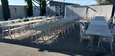 many tables and chairs set up outside under a tent