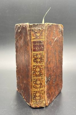 an old book sitting on top of a table next to a candle