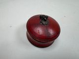 une petite boîte rouge surmontée d'une fleur