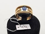 l'image d'une bague en or ornée d'une pierre bleue