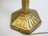 une lampe de table dorée posée sur une table blanche