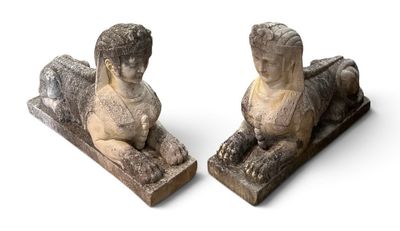 une paire de statues en pierre représentant un garçon et une fille assis sur un banc
