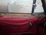 a red car with the door open and a steering wheel