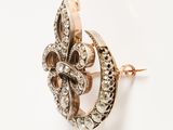 a close up of a gold and diamond broochle on a white background