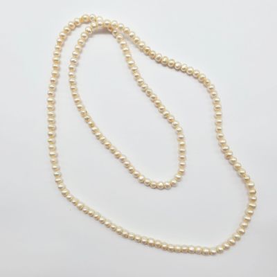 un collier de perles blanches avec un fermoir en or sur fond blanc