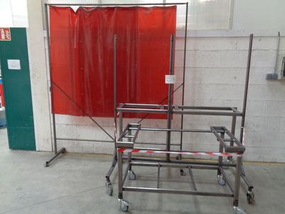 un rideau rouge accroché au mur à côté d'un chariot en métal