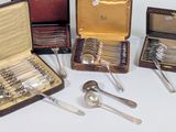 several silverware items are arranged in a case on a white surface