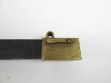 a close up of a brass buckle on a black belt