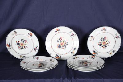 quatre assiettes ornées de motifs floraux sont posées sur une nappe bleue