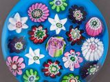 une assiette bleue décorée d'un bouquet de fleurs et de papillons