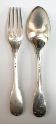 deux cuillères et une fourchette en argent sur une table