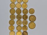 a close up of a pile of gold coins on a white surface