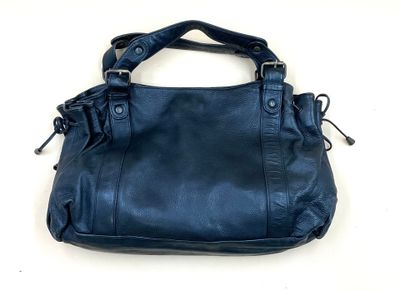 sac à main en cuir bleu avec des fermetures éclair et des anses, sur un fond blanc