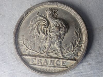 une pièce d'argent représentant un coq, posée sur une table
