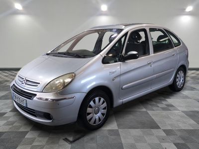 a picture of a small silver car parked in a garage