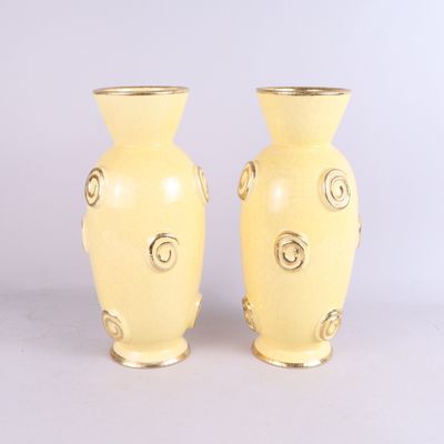 une paire de vases jaunes posés l'un à côté de l'autre sur une table