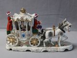 a figurine of a horse drawn carriage with people on it