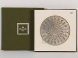 a box with a silver coin in it on a white surface