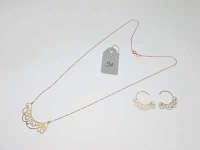 deux colliers en or et une paire de boucles d'oreilles avec une étiquette de prix