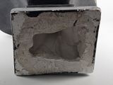 a statue of a cat sitting inside of a cement box