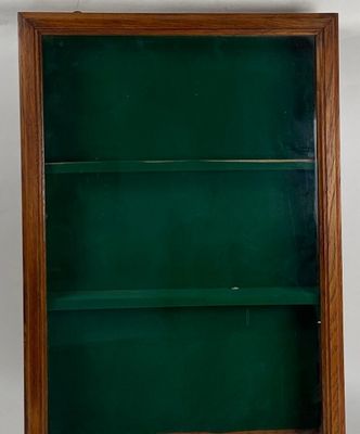 an old wooden bookcase with a green glass door