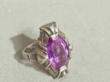 a close up of a ring with a purple stone in it
