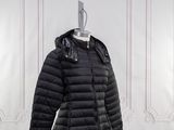 le manteau est noir et comporte une capuche