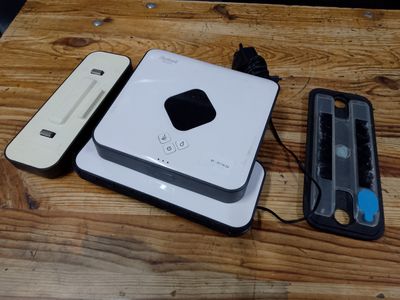 a white device sitting on top of a wooden table next to a remote