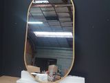 a mirror sitting on a table with a bird on it