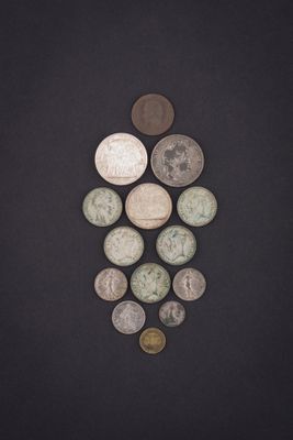 several coins are arranged in a triangle on a black surface