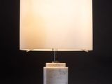 une lampe blanche avec un abat-jour blanc posée sur une table