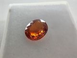 a close up of an orange diamond on a white surface