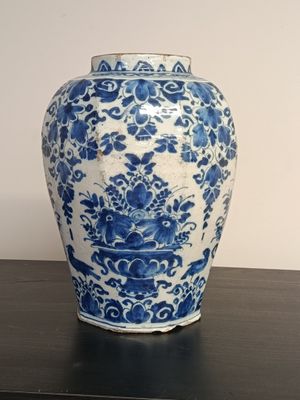 a blue and white vase sitting on a black table
