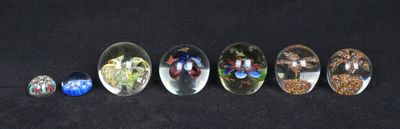 seven spoons with different designs on them on a black surface