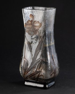 un vase en verre contenant une fleur, sur fond noir