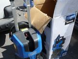 a blue and black cleaning machine next to a box of boxes
