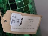 a green bottle with a tag on it sitting on a table