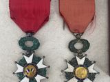 two medals and a book are sitting on a white surface
