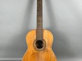 une vieille guitare en bois posée sur une surface grise