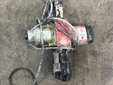 a drill that is laying on the ground next to a hose