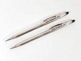 two pens sitting on top of a white table next to each other