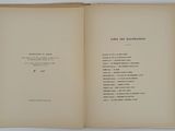 an open book sitting on top of a table next to a white wall