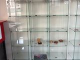 many glass shelves in the corner of a room