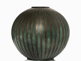 a green vase that is sitting on a white surface