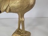 a gold statue of a rooster on a stand