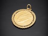 un pendentif en forme de pièce d'or sur lequel est représenté le visage d'une femme