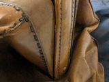 a close up of a brown leather bag on a table