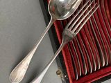 silverware in a red case with spoons and spoons on a table